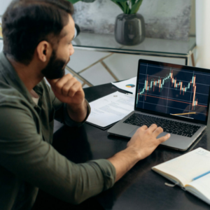Laptop screen with stock diagrams. Crypto trader investor broker using laptop for cryptocurrency financial market analysis, buying or selling cryptocurrency, planning strategy